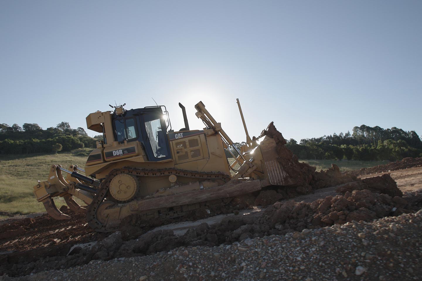 Caterpillar D8R tracked bulldozer working on a dirt and rock slope